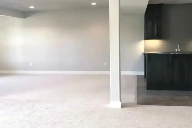 A painted interior wall being wiped clean with a sponge