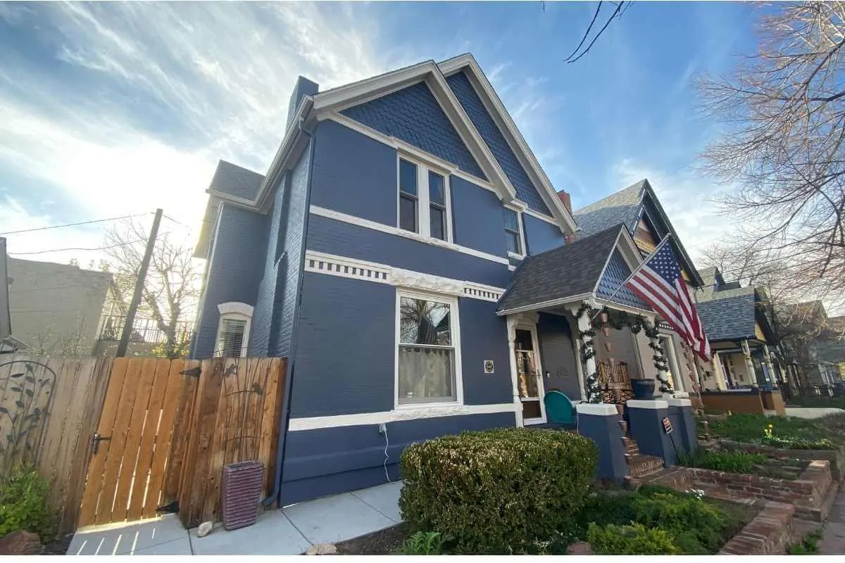 A blue and white Victorian home exterior painted by Kind Home Painting