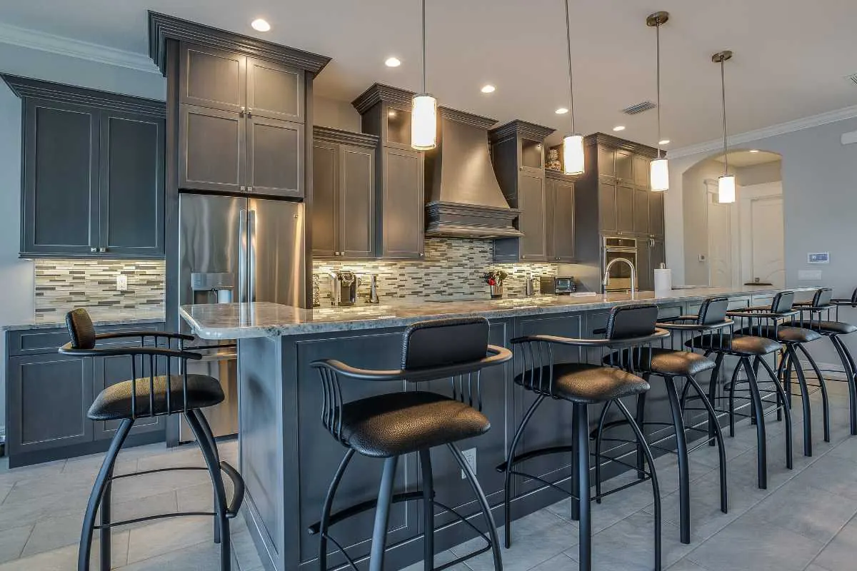 A kitchen with dark gray cabinets against a lighter wall color