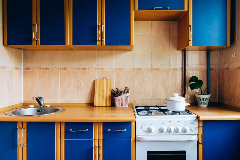 A dated kitchen with worn cabinets in need of refinishing