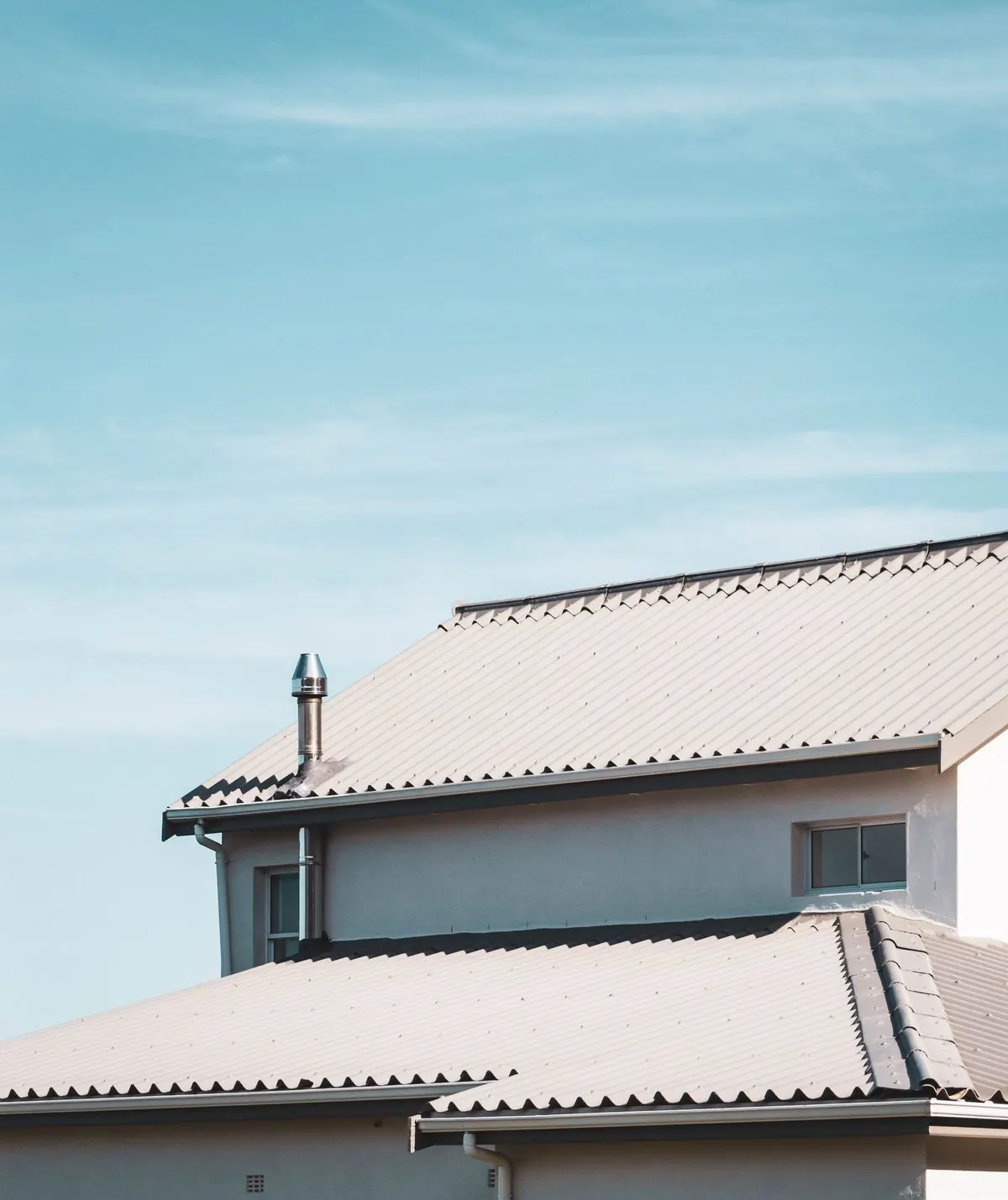 A continuous run of gutter along a clean residential roofline against blue sky